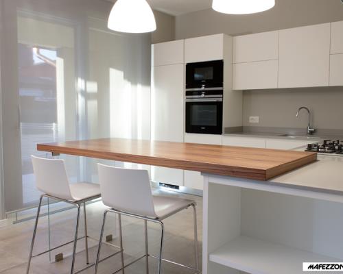 Cucina moderna in laminato bianco con antine smussate a 30° senza maniglie.